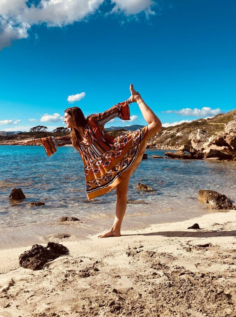 Elena Daenen in dancer pose on the beach